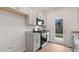 Beautiful kitchen featuring stainless steel appliances, gray cabinetry, and a door to the backyard at 208 Starlight St, Sanford, NC 27330