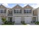 Inviting tan two-story townhome with a single-car garage and attractive landscaping at 216 Starlight St, Sanford, NC 27330