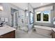 Bright bathroom featuring a glass enclosed shower, soaking tub, and serene grey color palette at 223 Harvester Rd, Angier, NC 27501