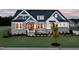 Charming two-story home showcasing stone accents, a covered porch, and manicured lawn at 223 Harvester Rd, Angier, NC 27501