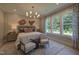 Serene bedroom with a plush bed, modern chandelier, and large windows offering natural light and views at 306 Golden Leaf Farms Rd, Angier, NC 27501
