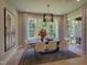 Elegant dining room with a modern chandelier, a dark wood table, and large windows overlooking the yard at 306 Golden Leaf Farms Rd, Angier, NC 27501