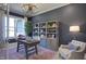 Stylish home office with dark blue walls, a wooden desk, and built-in shelving for a productive workspace at 306 Golden Leaf Farms Rd, Angier, NC 27501