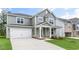 Two-story home with gray siding, white trim, a covered front porch, and an attached two-car garage at 309 Umstead St, Sanford, NC 27330