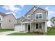 Two-story home with gray siding, white trim, a covered front porch, and an attached two-car garage at 309 Umstead St, Sanford, NC 27330