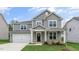 Two-story home with gray siding, white trim, a covered front porch, and an attached two-car garage at 309 Umstead St, Sanford, NC 27330