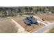 An aerial shot of a home with a metal roof, long driveway and landscaping situated on a large lot at 35 Wheatfield Ln, Youngsville, NC 27596