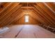 Unfinished attic space showcasing the home's wooden frame and a centered window at 35 Wheatfield Ln, Youngsville, NC 27596