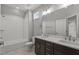 Bathroom features a double sink vanity with dark cabinets, neutral tile floor, and bathtub with white tile surround at 35 Wheatfield Ln, Youngsville, NC 27596