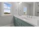 Bright bathroom features a double vanity with teal cabinets, white countertops, and a large mirror reflecting natural light at 35 Wheatfield Ln, Youngsville, NC 27596