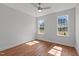 Bedroom with hardwood floors, a ceiling fan, and bright windows showcasing backyard views at 35 Wheatfield Ln, Youngsville, NC 27596
