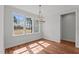 Bright dining nook featuring hardwood floors, a modern chandelier, and three large windows with natural light at 35 Wheatfield Ln, Youngsville, NC 27596