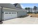 Attached garage featuring a white garage door and concrete driveway with landscaping at 35 Wheatfield Ln, Youngsville, NC 27596