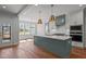 Open kitchen featuring a large island, quartz counters, stainless appliances, white cabinets, and hardwood floors at 35 Wheatfield Ln, Youngsville, NC 27596