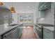 Bright open kitchen with quartz countertops, stainless appliances, white cabinets, light blue accents, and hardwood floors at 35 Wheatfield Ln, Youngsville, NC 27596