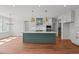 Bright, open kitchen with an island, quartz countertops, stainless appliances, white cabinets, and hardwood floors at 35 Wheatfield Ln, Youngsville, NC 27596