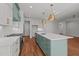 Kitchen featuring white cabinets, light blue island with quartz counters, brass hardware, and stainless steel appliances at 35 Wheatfield Ln, Youngsville, NC 27596