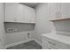 Modern laundry room features white cabinets, neutral countertops, and gray flooring at 35 Wheatfield Ln, Youngsville, NC 27596