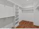 Large walk-in closet with built-in shelving and hardwood flooring at 35 Wheatfield Ln, Youngsville, NC 27596