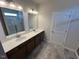 Bathroom featuring double sinks, white countertops, wood cabinets and a stand-up shower at 55 E Victory View. Ter, Smithfield, NC 27577