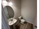 Elegant half bath with a pedestal sink, oval mirror, and stylish wood-look flooring at 55 E Victory View. Ter, Smithfield, NC 27577