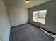 Bedroom with neutral walls, plush carpeting, and a large window at 55 E Victory View. Ter, Smithfield, NC 27577