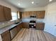 Bright kitchen featuring granite countertops, stainless steel appliances, and stylish wood cabinets at 55 E Victory View. Ter, Smithfield, NC 27577
