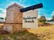 The brick and beam Buckhorn Branch community entrance sign is surrounded by fresh landscaping and green grass at 62 Blue Iris Pkwy # 125, Clayton, NC 27520