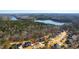 An aerial view shows the neighborhood's beautiful homes, mature trees, and proximity to a lake at 7212 Summer Tanager Trl, Raleigh, NC 27614