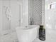 Well-lit bathroom boasts a soaking tub with black-and-white patterned backsplash and tiled floors at 7212 Summer Tanager Trl, Raleigh, NC 27614