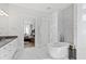 Bright bathroom features a modern soaking tub, marble floors, and decorative tile accents at 7212 Summer Tanager Trl, Raleigh, NC 27614