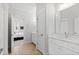 Bathroom featuring double sink vanities, wood look tile, neutral colors, and access to the Primary bedroom at 7212 Summer Tanager Trl, Raleigh, NC 27614
