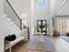 Grand two-story foyer featuring hardwood floors, a staircase, and elegant decor including a large window and chandelier at 7212 Summer Tanager Trl, Raleigh, NC 27614