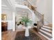 Grand foyer with hardwood floors, a staircase with iron railing, and a decorative center table with floral arrangement at 7212 Summer Tanager Trl, Raleigh, NC 27614