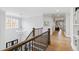Upstairs landing with hardwood floors, stylish lighting, and a view of the foyer below at 7212 Summer Tanager Trl, Raleigh, NC 27614