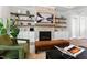 Cozy living room area features a fireplace with shelving, a comfortable chair, and hardwood floors at 7212 Summer Tanager Trl, Raleigh, NC 27614