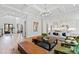 Open-concept living room with hardwood floors, coffered ceilings, and views into the kitchen at 7212 Summer Tanager Trl, Raleigh, NC 27614