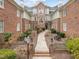 Inviting brick courtyard entrance with landscaped garden and walkway leading to the building's entrance at 100 Edenburgh Rd # 202, Raleigh, NC 27608