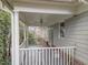 Covered porch with white railing, ceiling fan, vinyl siding, and brick accents at 100 Edenburgh Rd # 202, Raleigh, NC 27608