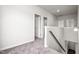 Upstairs hallway with carpet, white walls, and wood railing at 106 E Victory View. Ter, Smithfield, NC 27577