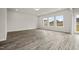 Bright living room with vinyl flooring and large windows offering views of the neighborhood at 106 E Victory View. Ter, Smithfield, NC 27577