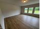 Large living room featuring hardwood floors and natural light from three windows at 106 E Victory View. Ter, Smithfield, NC 27577