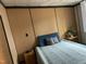 Comfortable bedroom featuring paneled walls, a bed with blue headboard, and simple decor for a cozy retreat at 117 Lone Star Dr, Louisburg, NC 27549