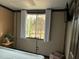 Relaxing bedroom with paneled walls, a bright window with curtains, and a vintage trunk as decor at 117 Lone Star Dr, Louisburg, NC 27549