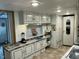 Bright kitchen area with white cabinets, open shelving, and modern appliances for efficient cooking at 117 Lone Star Dr, Louisburg, NC 27549