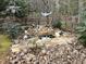 Landscaping with a small pond with rocks and figurines at 117 Lone Star Dr, Louisburg, NC 27549