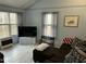 Comfortable living room with large windows offering natural light, and an inviting brown sofa at 117 Lone Star Dr, Louisburg, NC 27549