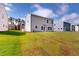 Wide backyard shot with grass, and house with large windows, under a blue sky at 1229 Dimaggio Dr # 8, Raleigh, NC 27616