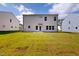 Large grassy backyard with view of back exterior with door and large windows at 1229 Dimaggio Dr # 8, Raleigh, NC 27616