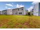 A wide backyard shot with lush grass, with a large house under a blue sky at 1229 Dimaggio Dr # 8, Raleigh, NC 27616